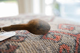 A close-up of the rustic, hand-carved bowl of the vintage African wooden spoon.