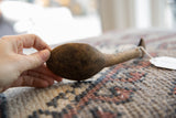 Dark, textured wood bowl of a vintage African spoon held in hand for scale.