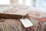 Carved geometric handle and attached paper tag of a vintage wooden spoon.