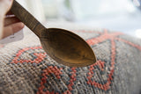 Close view of the rich patina and etched designs on a vintage African wooden spoon.