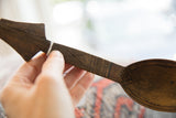 Detail of the spade-shaped finial and hand-etched handle of a vintage African spoon.