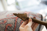 Hand-carved handle of a vintage African wooden spoon showing its aged texture.