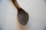 Close-up of the vintage wooden spoon's bowl showing its deep, aged patina and texture.