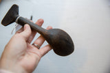Vintage African wooden spoon held in hand to show its scale and aged finish.