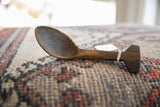 Vintage African spoon with weathered wood grain and a unique, hand-carved handle.