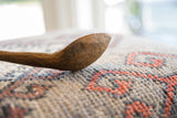 Close-up of the rustic, weathered surface on the hand-carved African spoon bowl.