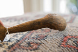 A natural knot and hand-carved texture on the aged wood of a vintage African spoon.