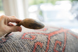 Worn texture and hairline cracks on the dark wood of the vintage spoon bowl.