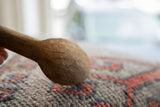 The aged, textured surface of a hand-carved vintage wooden spoon bowl.