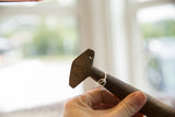 Close-up of the angular T-shaped handle on a vintage African wooden spoon.