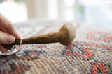 Incised line detail and aged wood grain on the handle of a vintage African spoon.