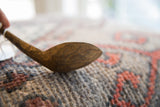 The deep wood grain and hand-carved character of a vintage African spoon.