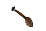 Hand-carved vintage African wooden spoon with a dark patina and incised patterns on the handle.