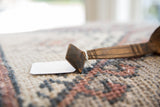 Carved diamond-shaped finial with etched lines on the aged African wooden spoon.