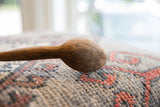 Close-up on the rustic, hand-carved bowl of a vintage African wooden spoon.