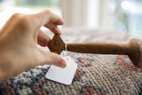 Hand holding the diamond-shaped handle of a vintage, hand-carved African wooden spoon.