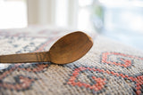 Close-up showing the aged wood grain and hand-carved texture of the vintage spoon.