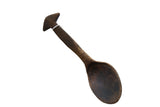 Hand-carved vintage African wooden spoon with a dark, rustic finish and triangular handle finial.