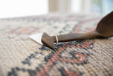 Carved details on the unique triangular handle of a vintage wooden spoon.