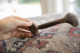 Vintage African wooden spoon held in hand to display its profile and aged texture.
