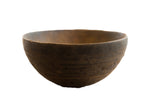 Vintage African wooden bowl with a dark, rustic texture and faint, hand-carved patterns.