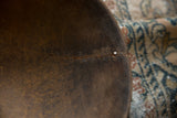 Close-up of a traditional stitched repair along a crack in the dark wood bowl.