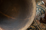 Aged interior of a vintage wooden bowl showing the dark, textured surface with natural cracks.