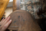 A hand feeling the time-worn, textured surface of the vintage wooden bowl.