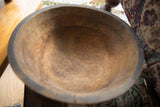 Aged, textured interior of a vintage African wooden bowl showing dark wood grain.