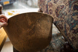 Angled close-up of a vintage African wooden bowl's rustic, textured surface.