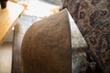 A unique stitched repair detail on the textured, aged wood of an African bowl.