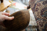 Detail of the hand-carved geometric patterns on the dark wood of a vintage bowl.
