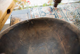 A detailed look at the textured wood, cracks, and repairs inside the vintage African bowl.