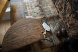 Angled view of a vintage African wooden bowl's dark, hand-carved surface details.
