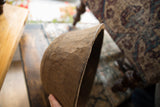 A detailed view of the vintage wooden bowl's hand-carved texture and thick rim.