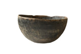 Vintage handmade African wooden bowl with a dark, time-worn patina and uneven rim.