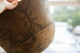 Close-up of vintage African wooden bowl exterior with carved geometric patterns and rich patina.