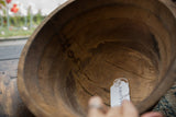 Vintage African wooden bowl interior, showcasing prominent aged cracks and zig-zag repairs.