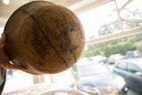 Vintage African wooden bowl with aged texture, prominent cracks, and staple repairs.