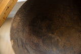 The characterful, time-worn texture of the dark wood inside the vintage African bowl.