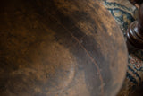 Traditional stitched repairs and aged patina on the interior of a vintage wooden bowl.