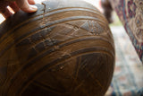 Detailed view of hand-carved patterns and an aged crack on a vintage African wooden bowl.