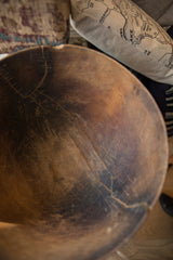 Time-worn surface and character-rich cracks of a vintage African wooden bowl.