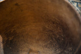 Warm wood grain and aged patina on the interior of a handmade African bowl.