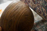 A band of carved geometric patterns and incised lines on the vintage wooden bowl.