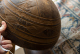 Hand-carved patterns and storied cracks showing the age of a vintage African wooden bowl.