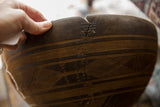 Close-up of a traditional metal staple repair along a crack on the vintage wooden bowl.