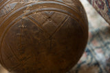 Carved geometric patterns and a historic metal staple repair on a vintage African wooden bowl.