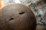 Close-up of a natural crack and indentations on the aged wooden bowl's surface.