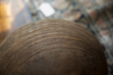 Intricate hand-carved lines and textures on the exterior of a vintage wooden bowl.